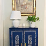blue cabinet with white lamp and plant