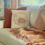 DIY pumpkin pillow on sofa with orange pillow